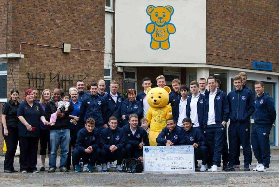 The team pose for a photo with the cheque along with staff