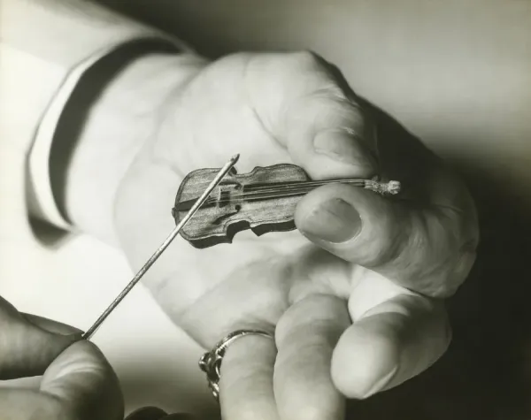 man-holding-tiny-violin-close-hands-12306125.jpg