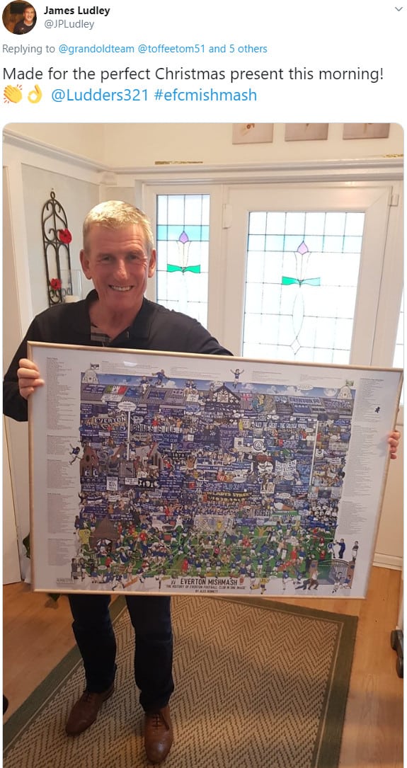 A proud Evertonian holding up his framed Everton Mishmash football art print at home.